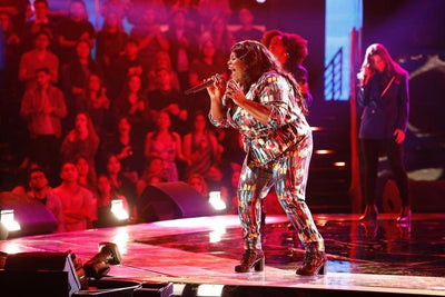 singer performing on plus size sequin suite